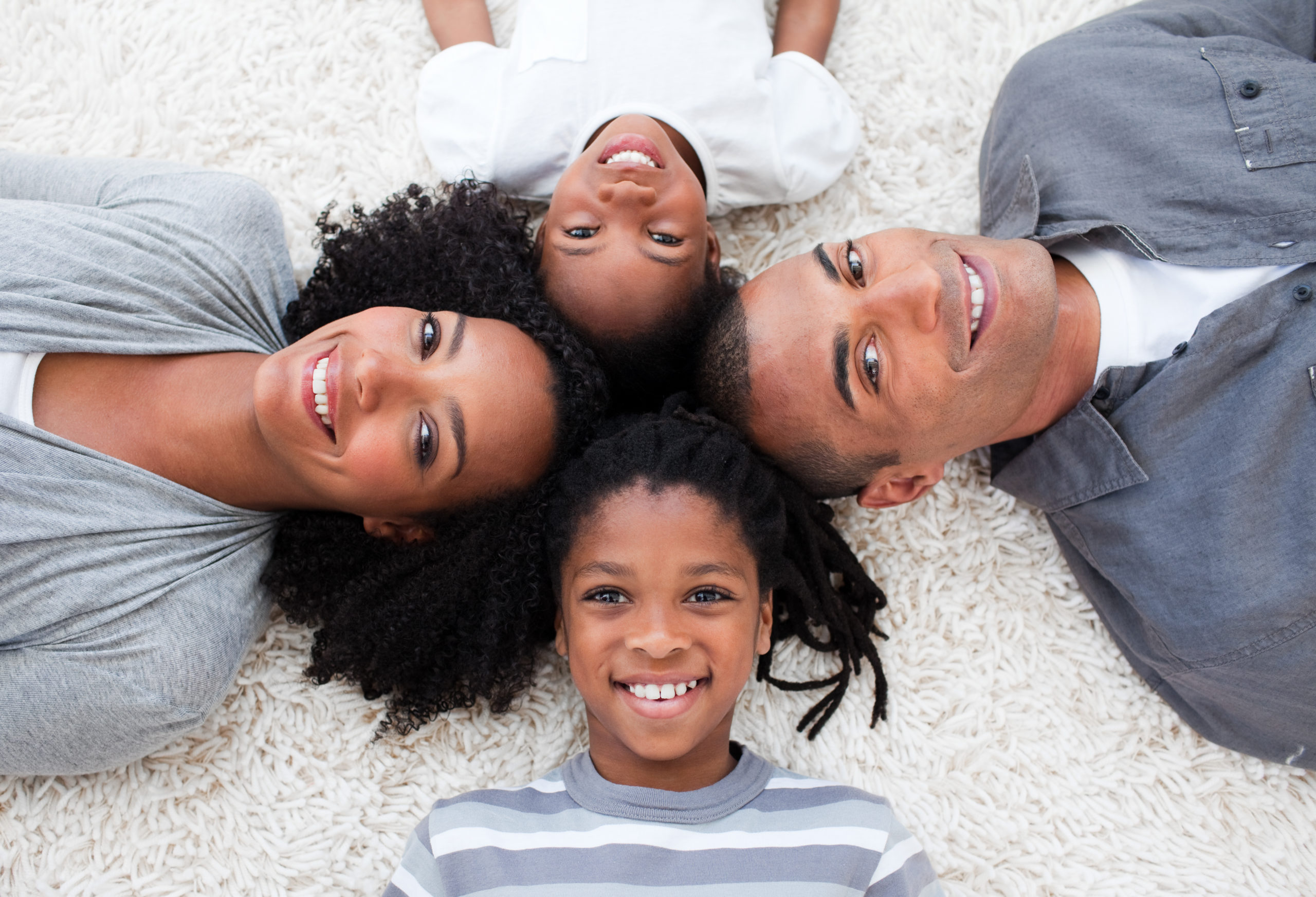 Smiling Young Family Lying on Floor